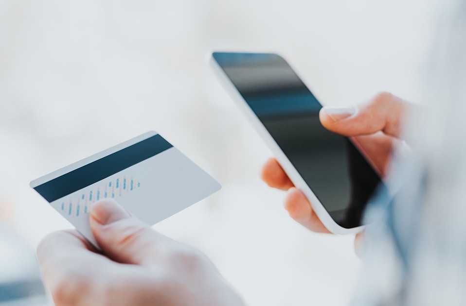 young man hands holding credit card and using phone