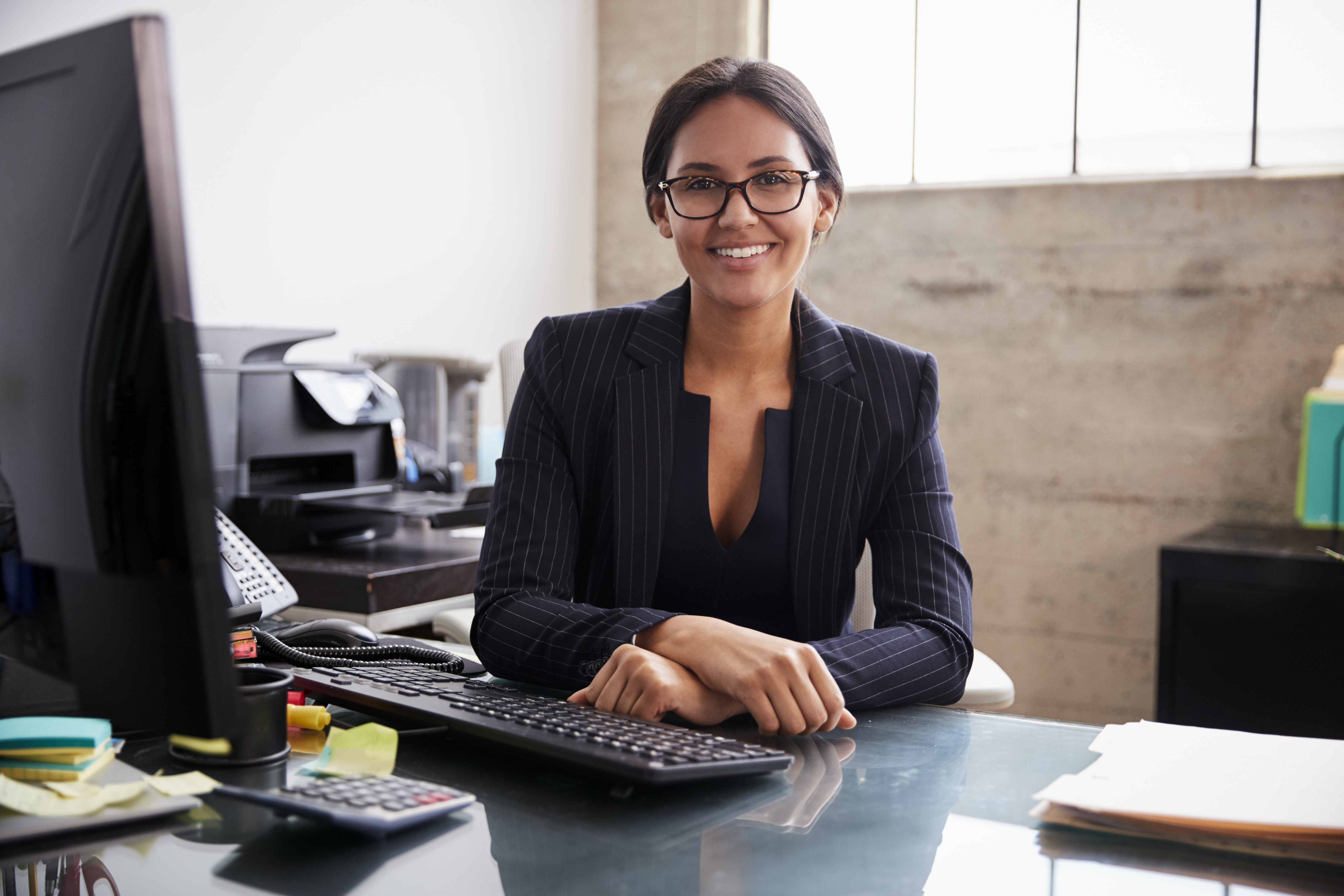 Young professional mixed race woman sitting in an office